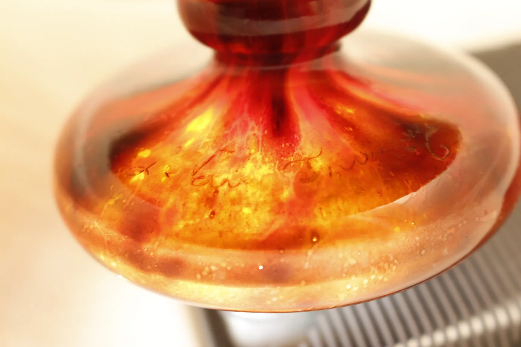 ग्लास पर हस्ताक्षरित Le Verre जिसमें जीवंत फूलों का डिजाइन है, प्राचीन परिवेश में।