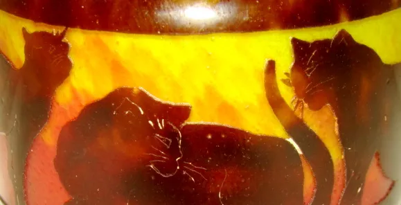 Vidrio firmado con diseño de gatos en tonos cálidos.