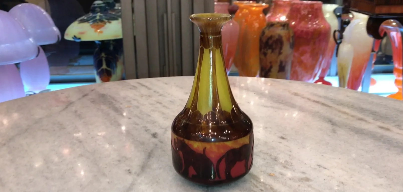 Antique signed glass Le Verre with vibrant colors, unique shape against a soft background.