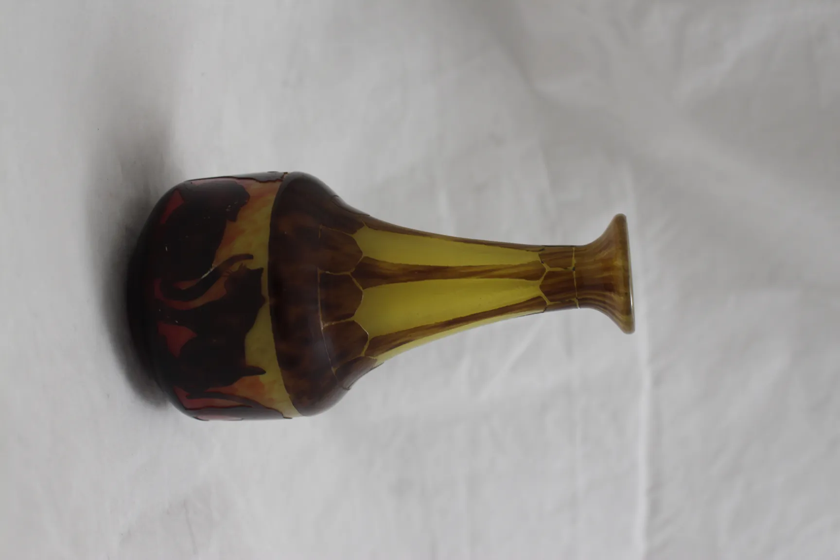 Vidrio firmado le Verre con diseño decorativo en tonos dorados y marrones, forma elegante.