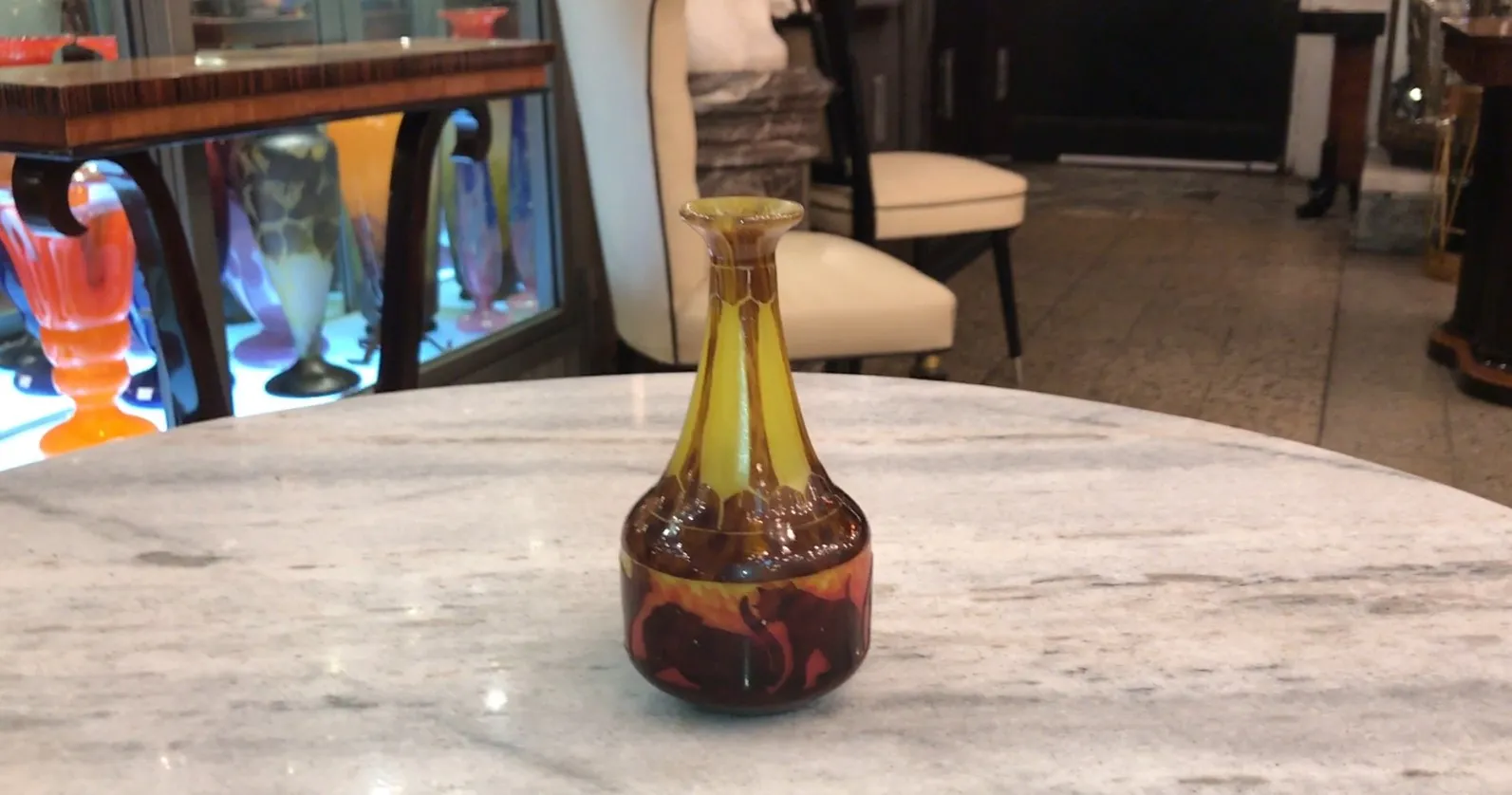 棕色玻璃瓶，背景是橙色的大象设计，摆放在大理石桌上