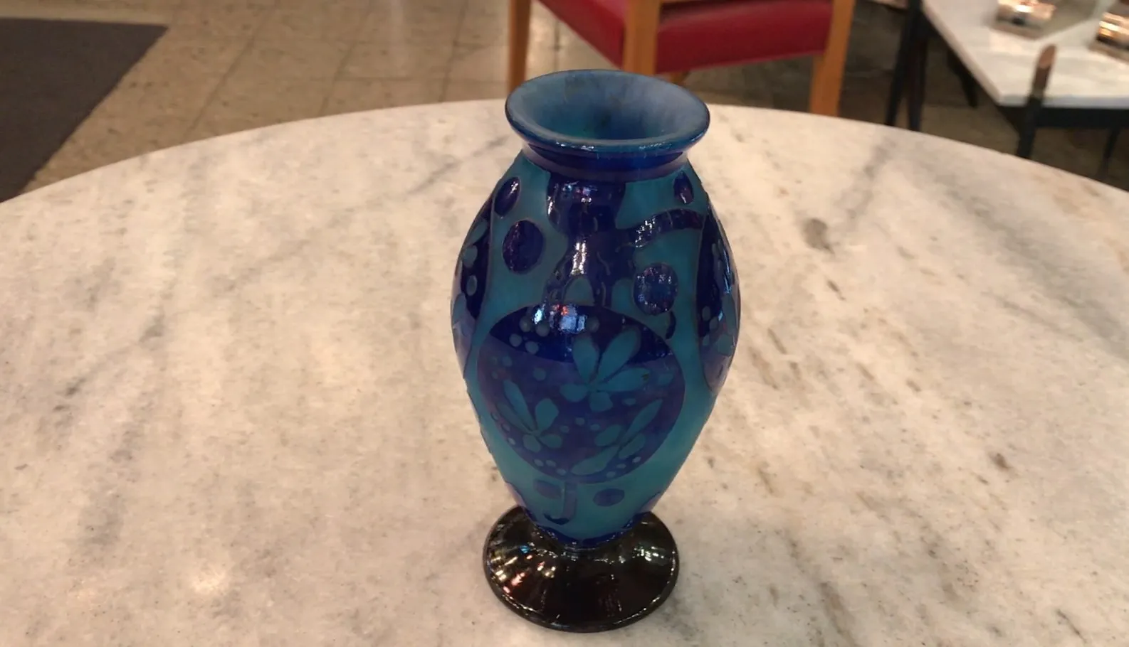 Blue glass vase with intricate patterns in antique setting.