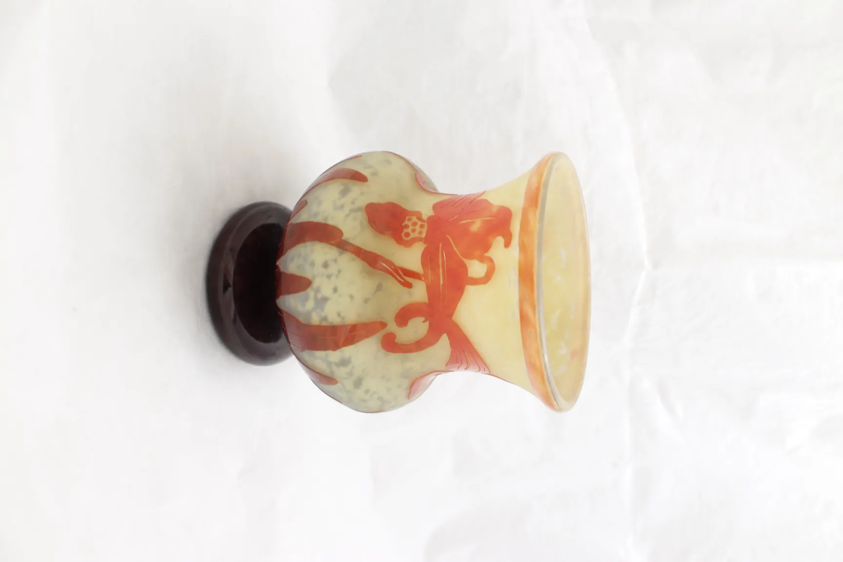 Antikes signiertes Glas Le Verre mit lebhaftem Design auf dunklem Sockel.