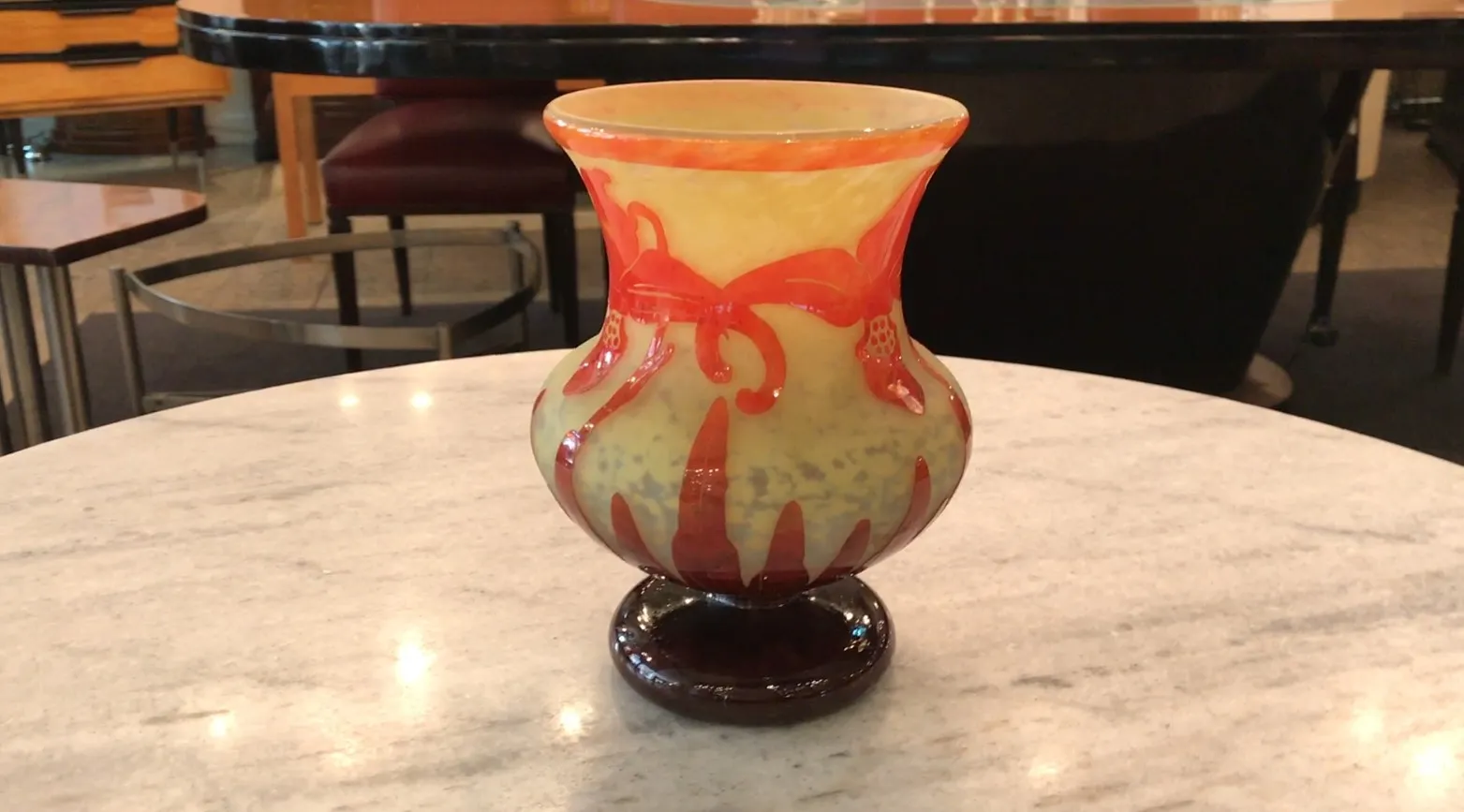 서명된 유리잔 Le Verre, 밝은 배경에 빨간 장식 디테일이 있는 테이블 위에