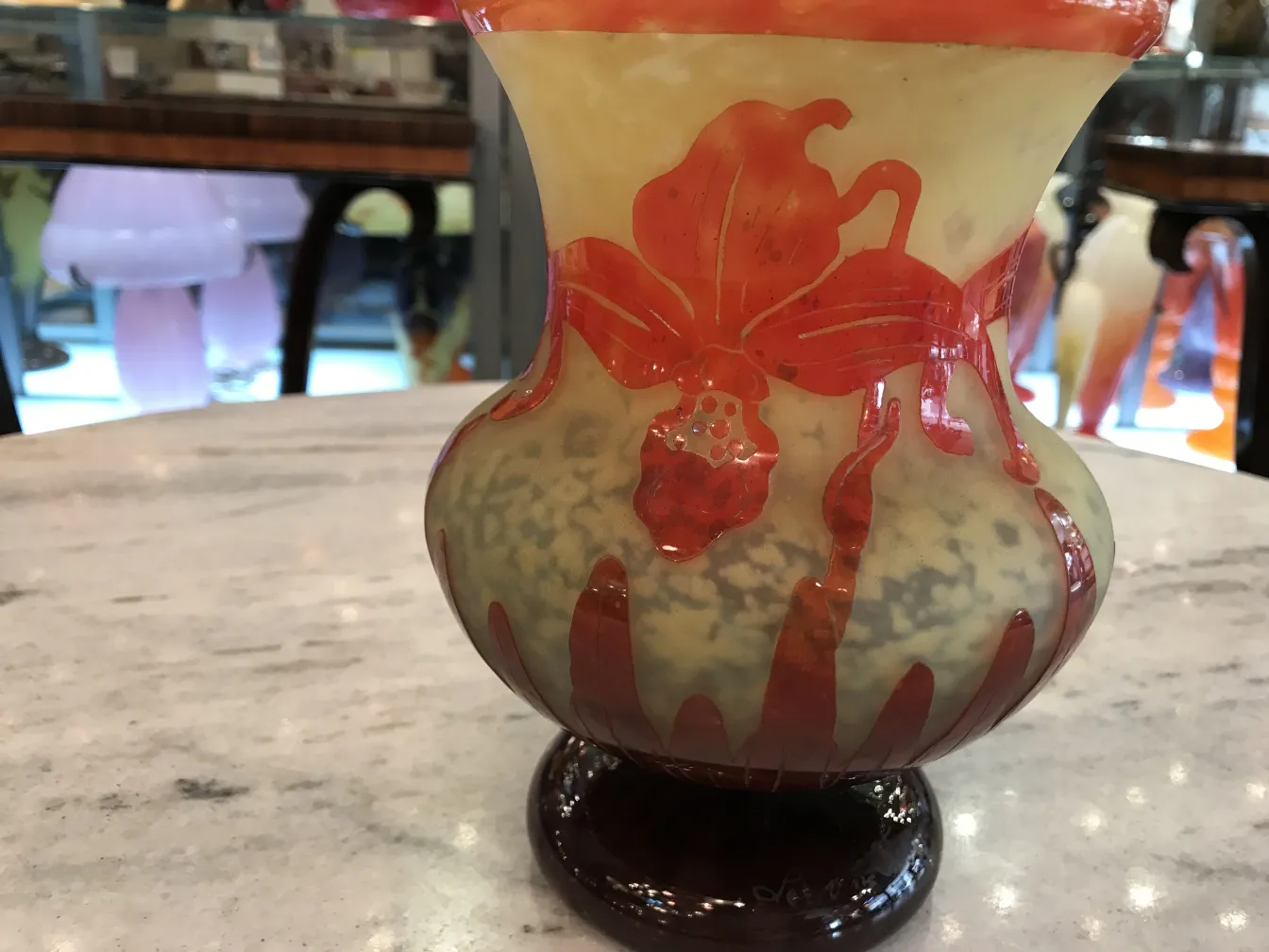 jarrón de vidrio firmado con diseño de flores en fondo claro