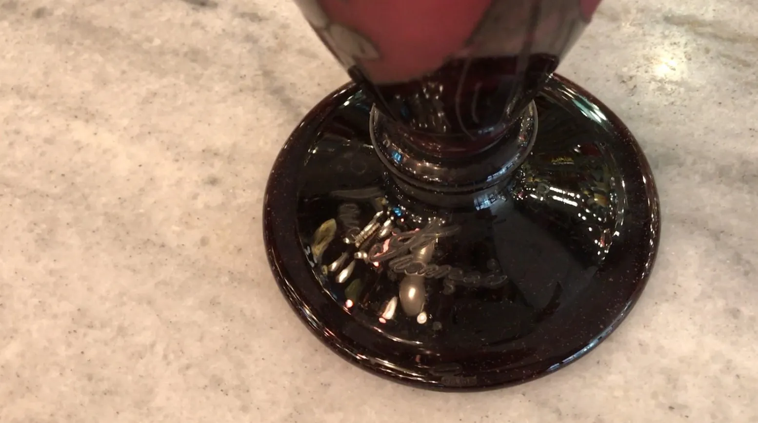 signiertes glas mit detailliertem fuß und subtilen dekoren