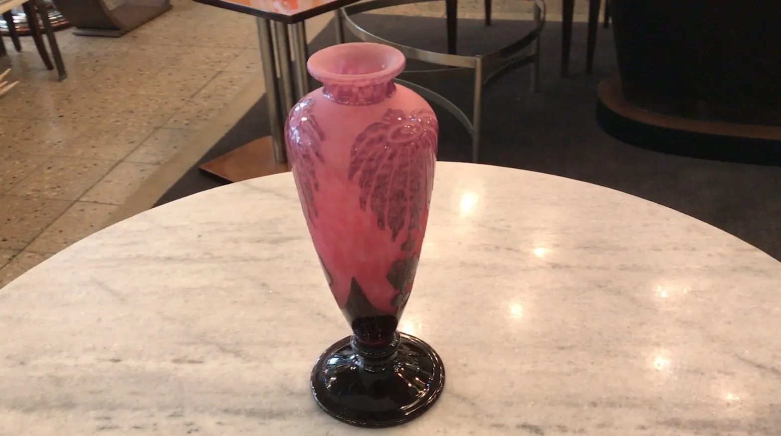 Antiga vasilha de vidro assinado Le Verre com design elegante e colorido, decorando uma mesa de mármore.