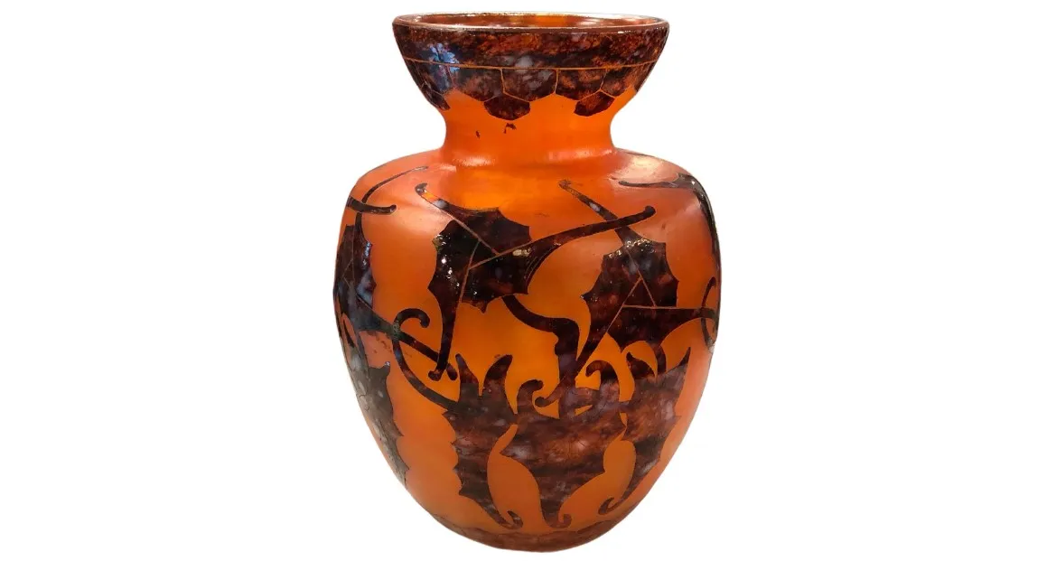 Antique signed glass vase Le Verre with decorative leaf patterns in warm tones.
