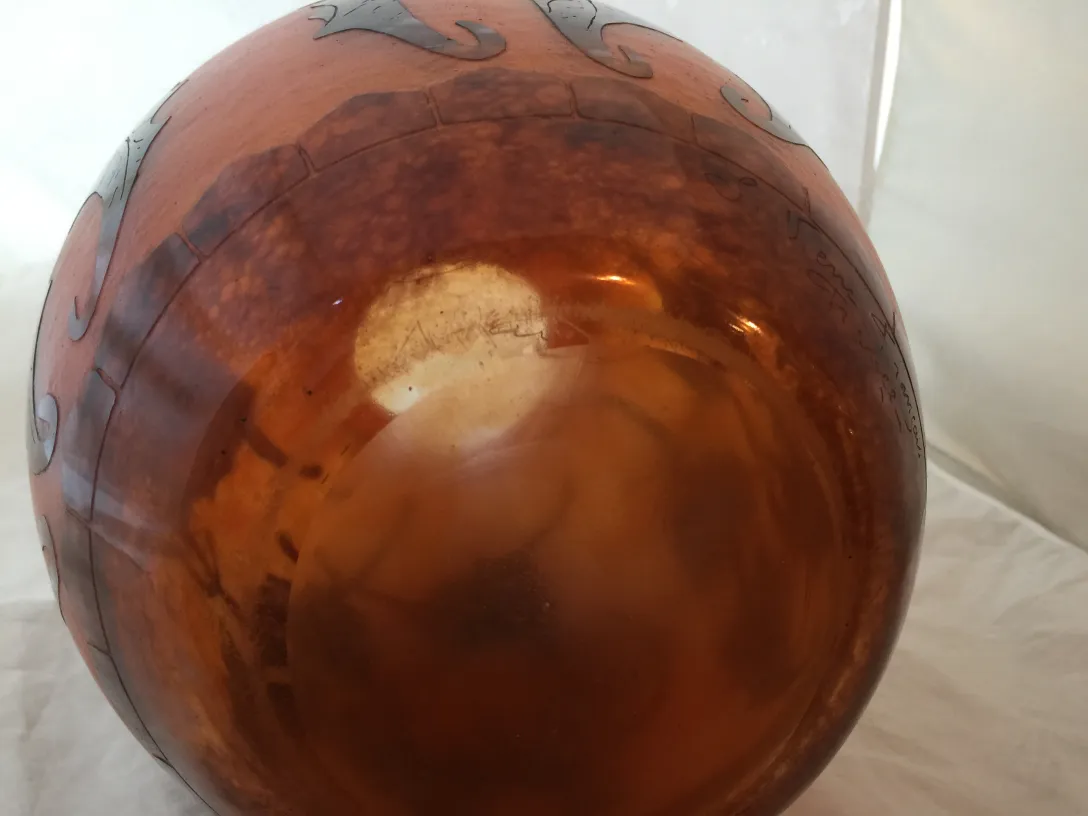 Vidro antigo com assinatura e detalhes decorativos visíveis