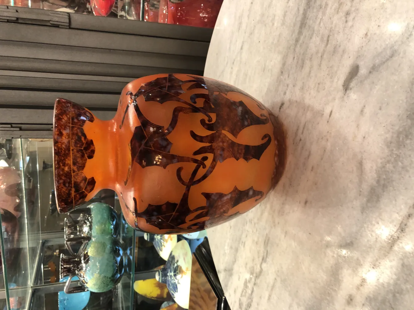 古董玻璃作品，展现优雅的橙色和棕色图案，陈列在古董环境中