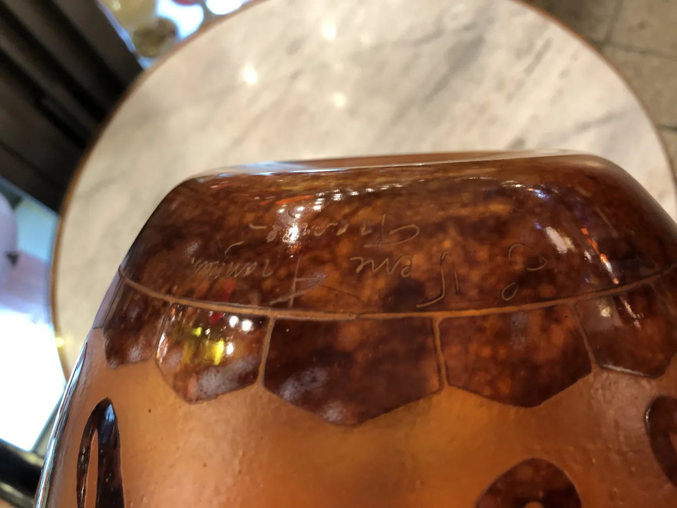 Signiertes Glas Le Verre mit warmen Details und glänzendem Hintergrund.