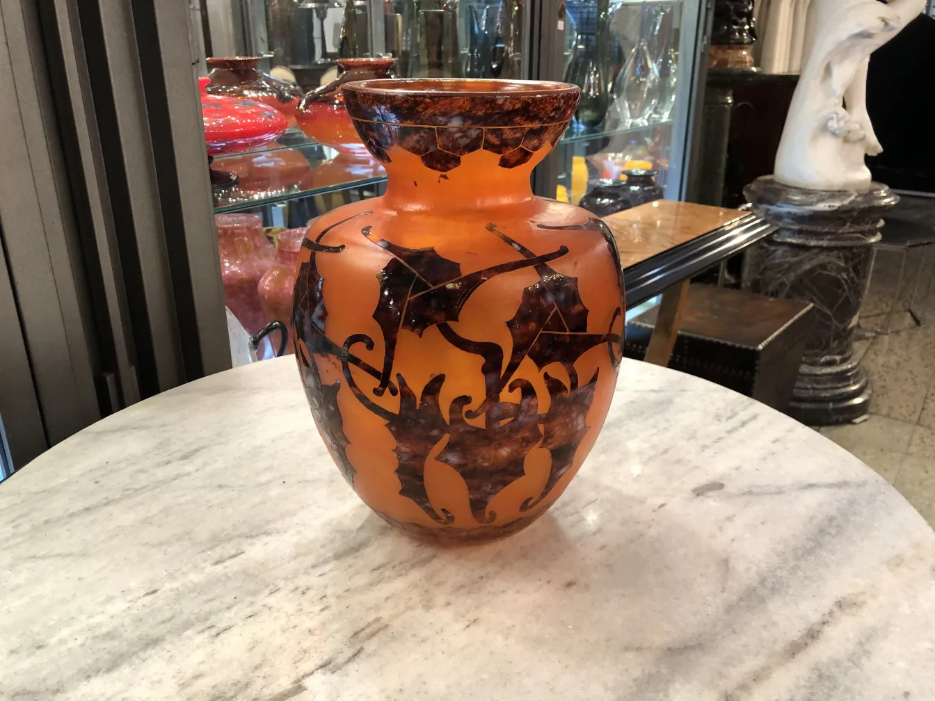 antik glas vase mit schwarzem und orangefarbenem design vor elegantem hintergrund