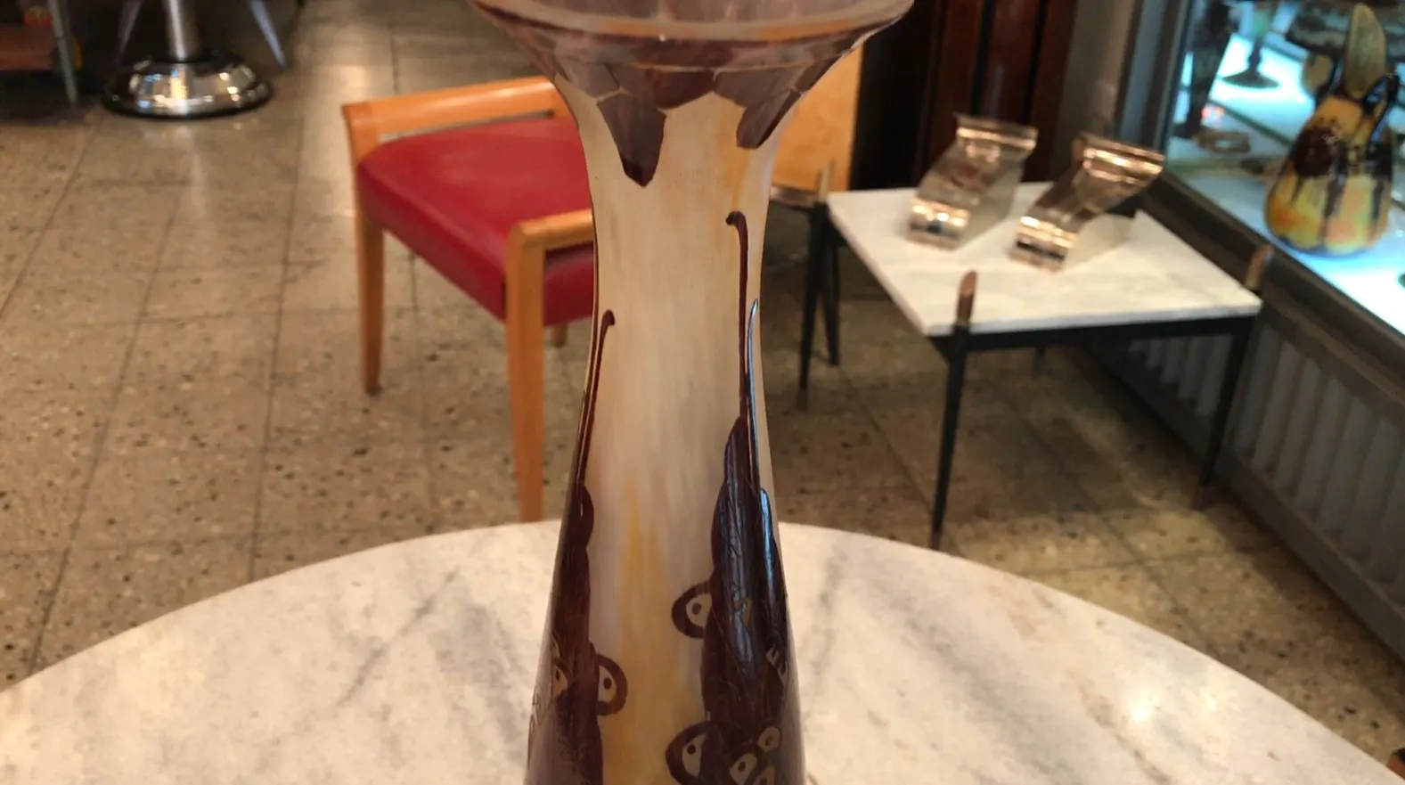 Signiertes Glas Le Verre mit warmen Tönen, in einer antiken Umgebung.