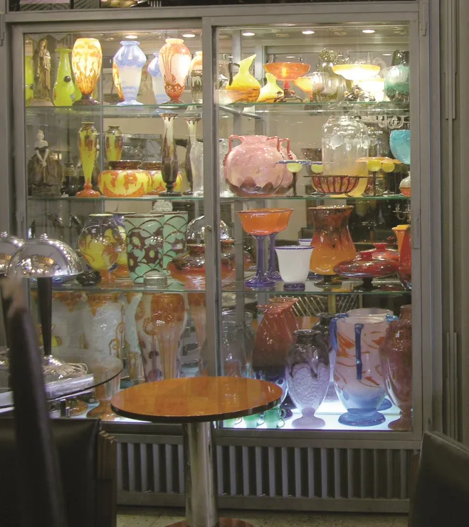 vitrine avec des antiquités, y compris le verre signé Le Verre français
