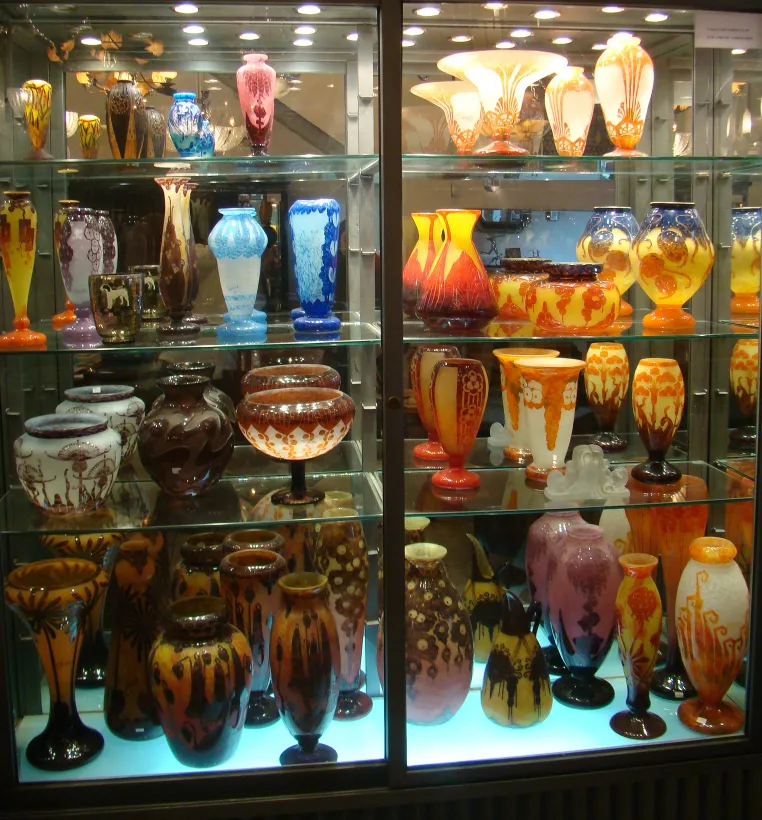 Vitrines avec des antiquités en verre signé aux couleurs et formes variées.