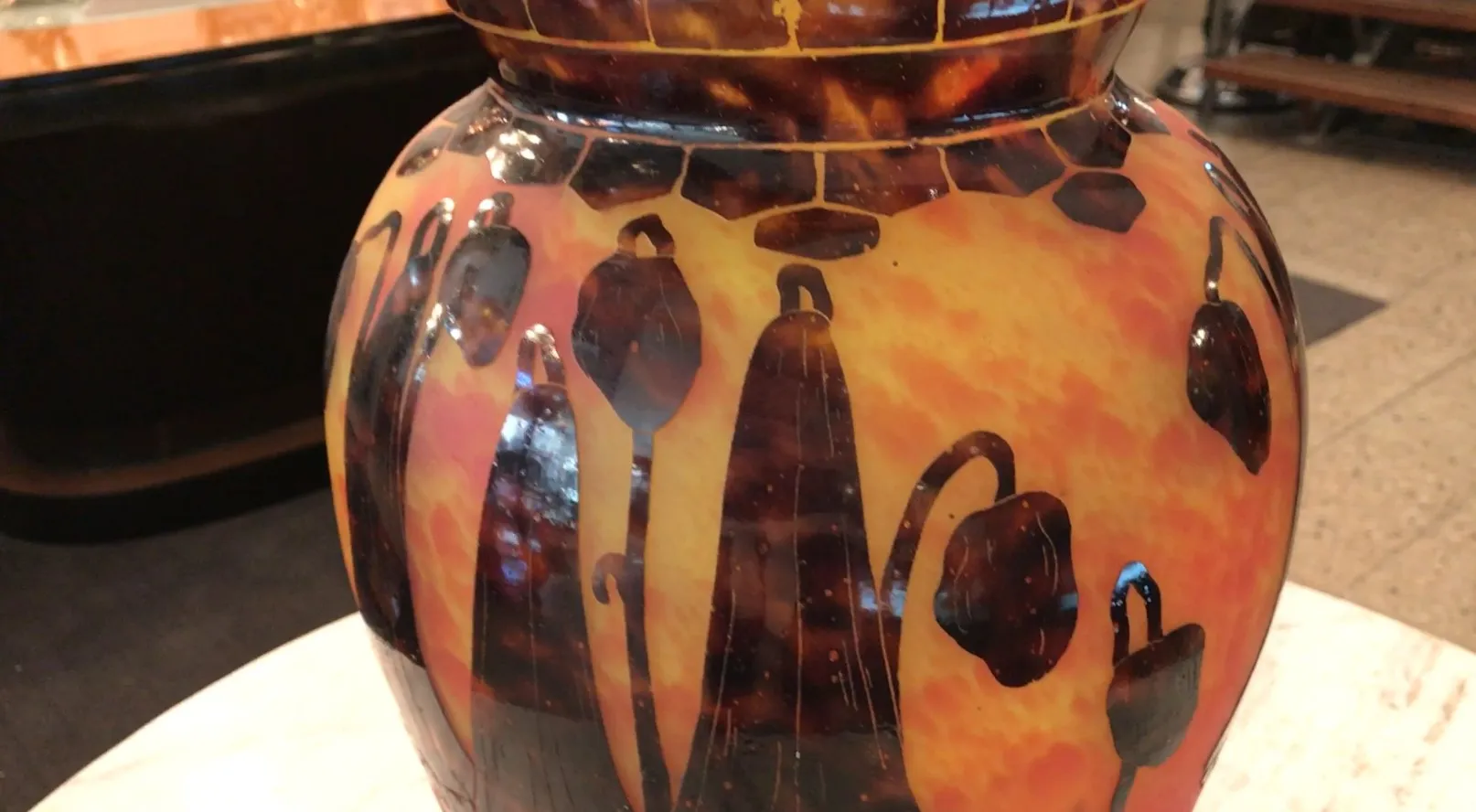 Vaso antiguo de vidrio con diseño floral en tonos cálidos