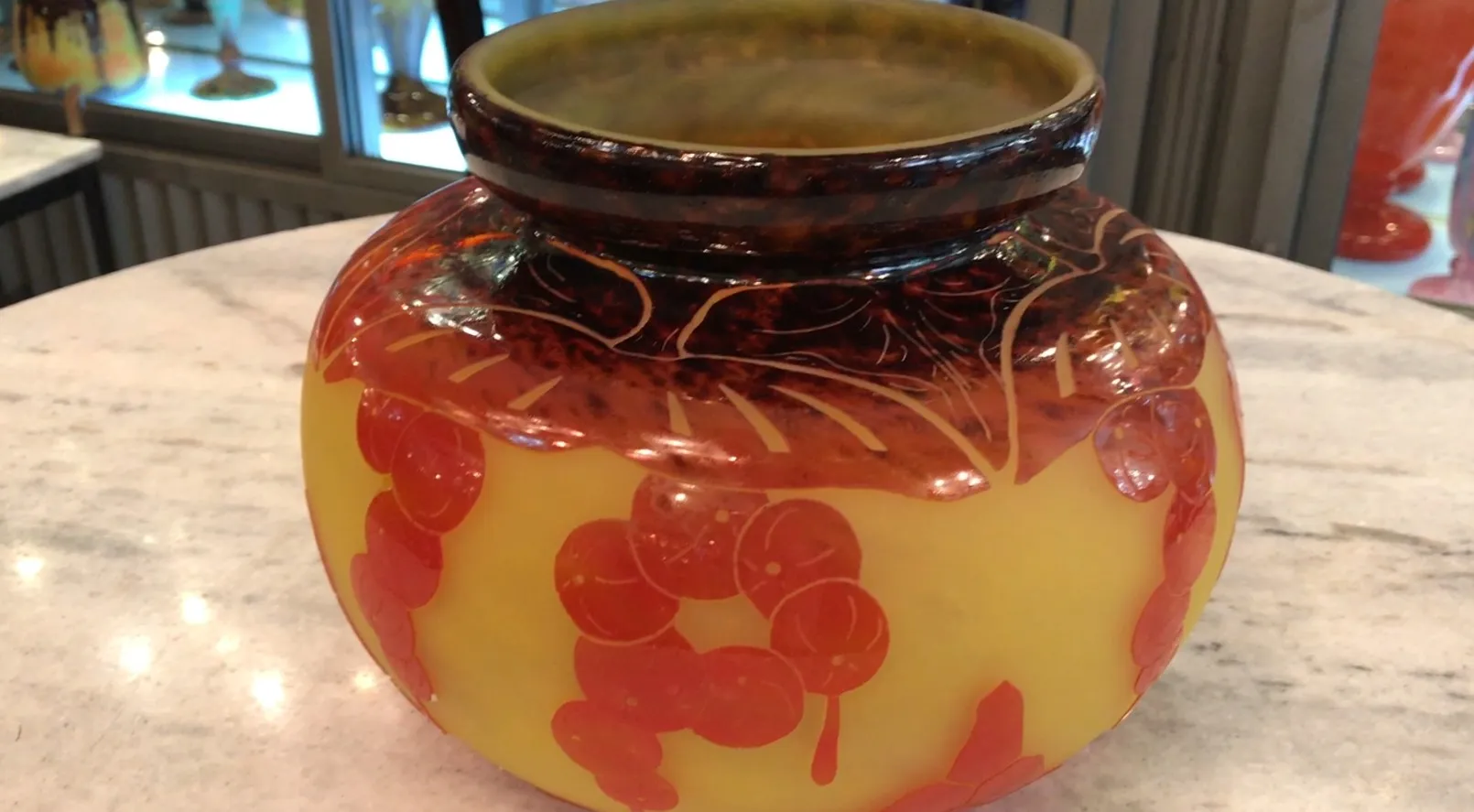 زجاج موقّع le verre بزخرفة حمراء على خلفية صفراء.