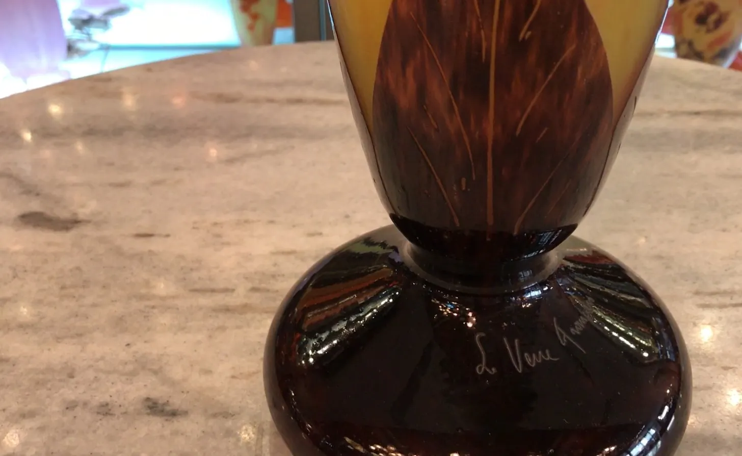 Vetro antico firmato con dettagli marroni e chiari, atmosfera elegante.