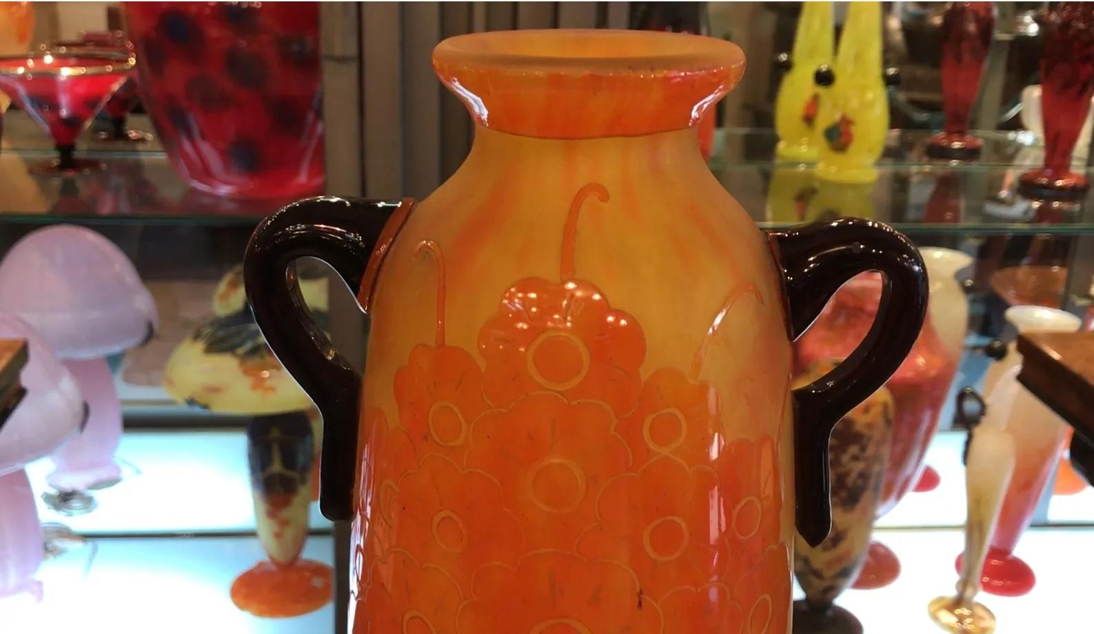 antigo vidro decorativo assinado le verre em uma vitrine colorida