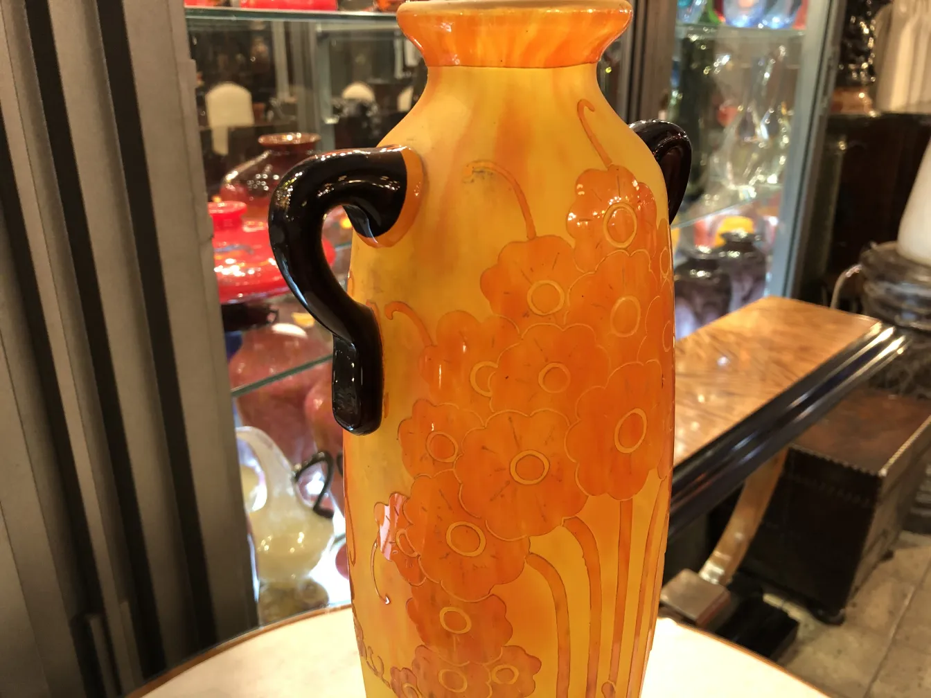 Vaso antiguo de vidrio firmado Le Verre, con flores naranjas.