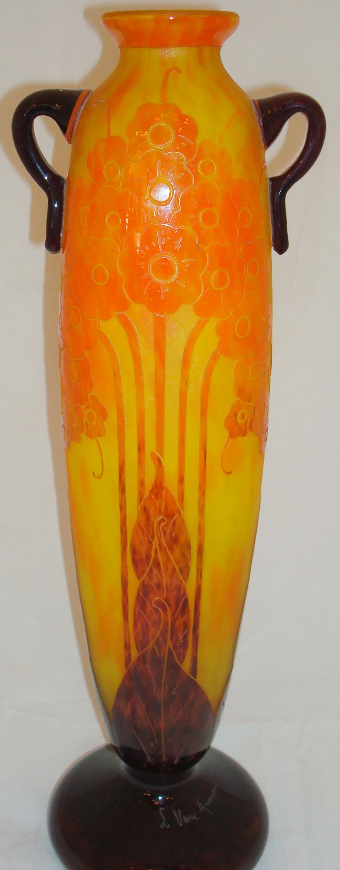Vase en verre signé Le Verre avec des décorations en tons jaunes et oranges.