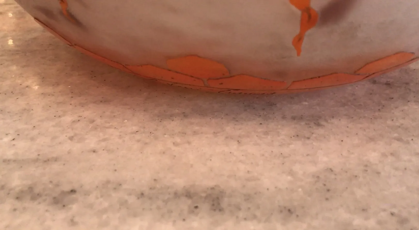 Vidro assinado Le Verre com detalhes decorativos em laranja sobre uma superfície clara