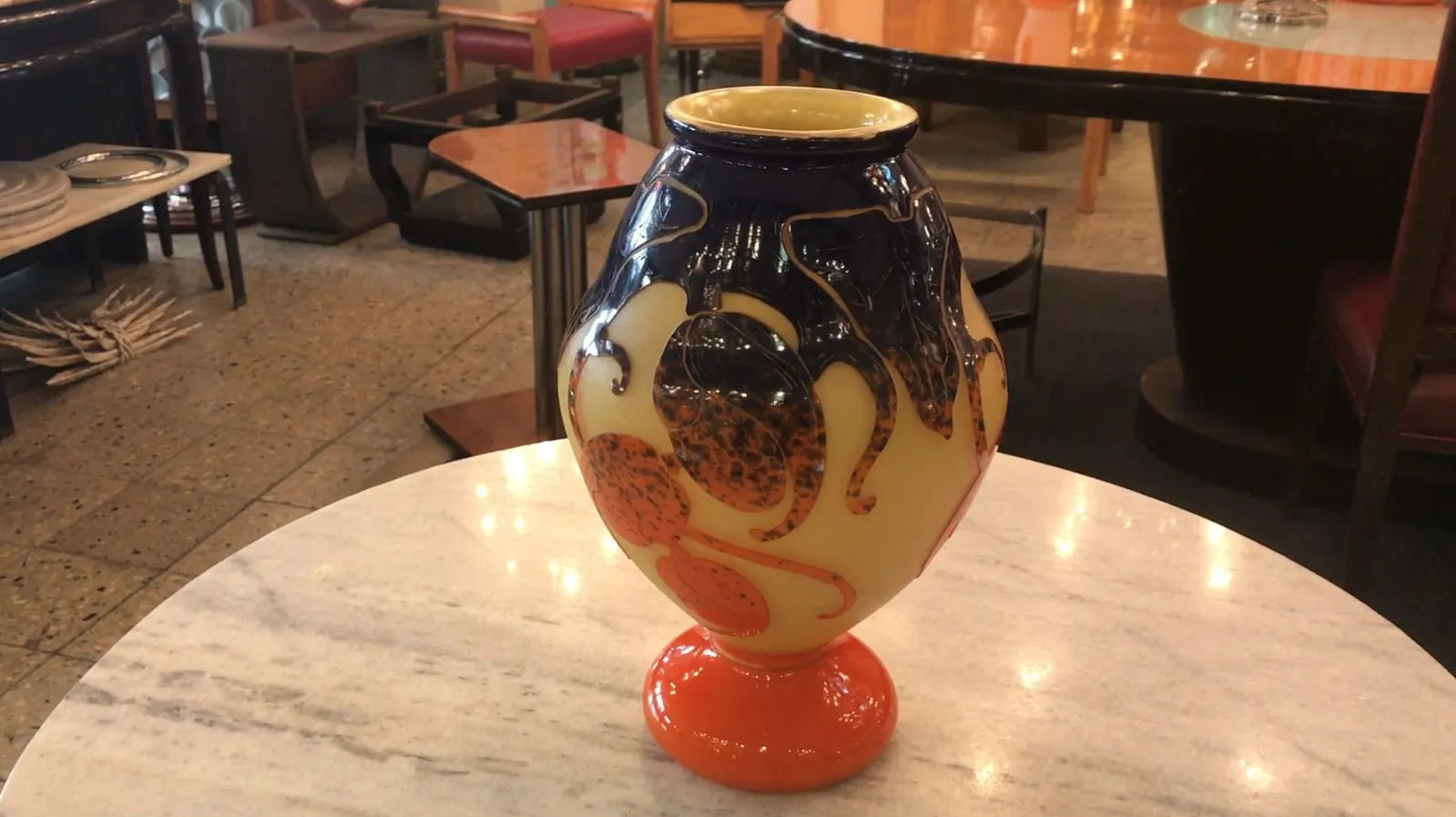 Antiguidades vidro assinado Le Verre com decoração vibrante, exposto em ambiente moderno.