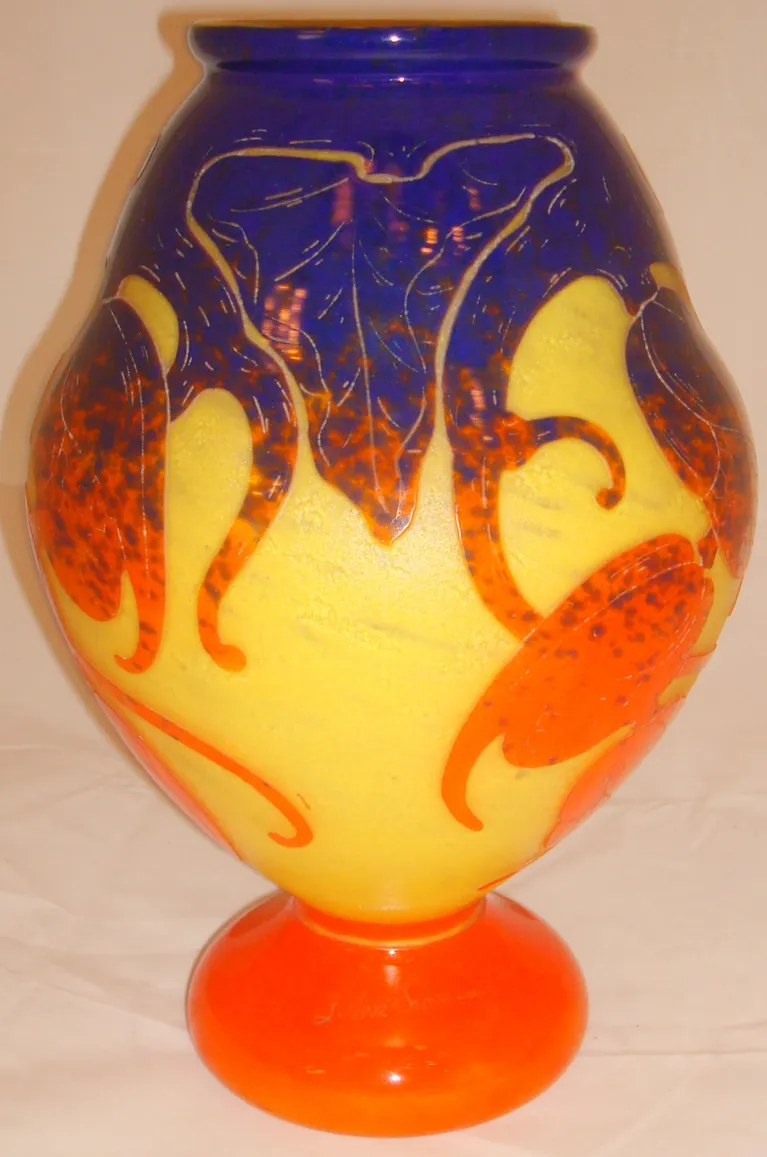 Élégant verre ancien signé Le Verre avec décoration florale et couleurs vibrantes, base orange.