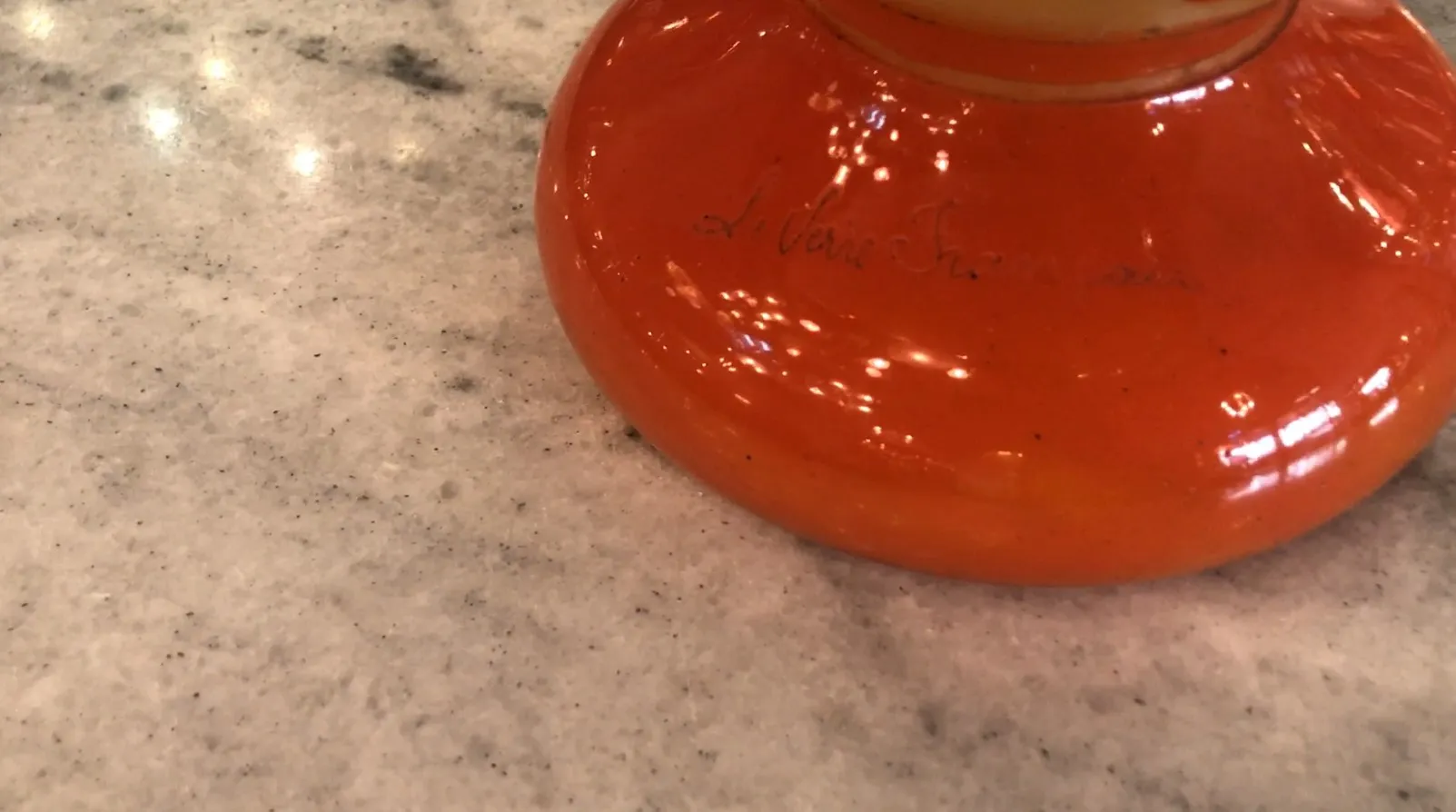 Verre signé Le Verre orange éclatant sur une table claire
