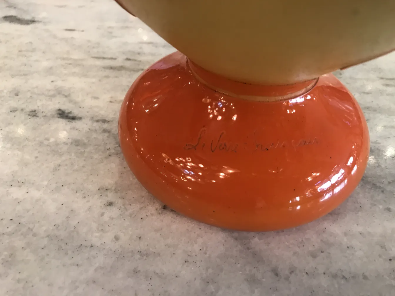 Vidro assinado com base laranja, detalhe da assinatura.