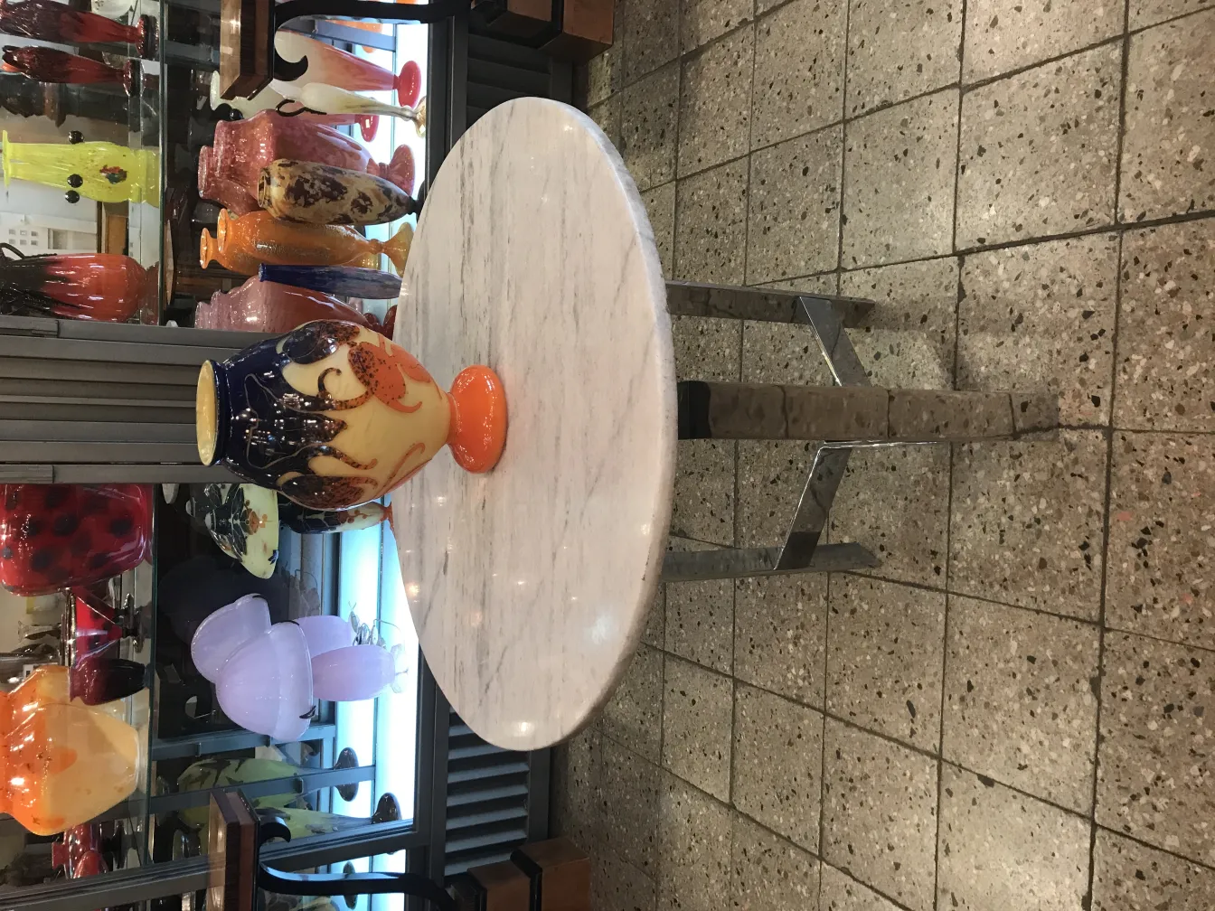 vase de verre signé Le Verre avec des couleurs vives sur un fond décoratif