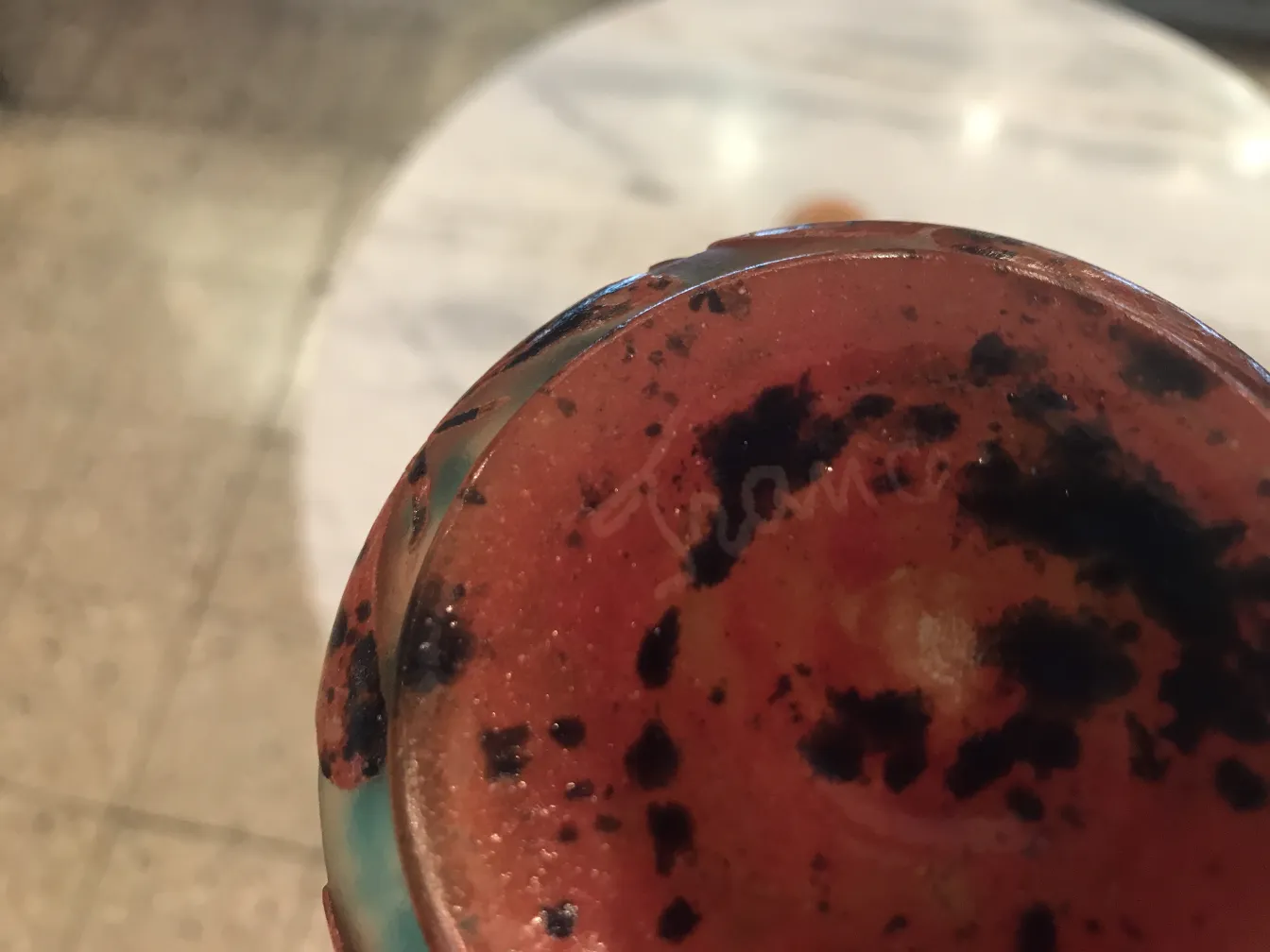 verre signé ancien avec taches sombres et design coloré dans un environnement élégant