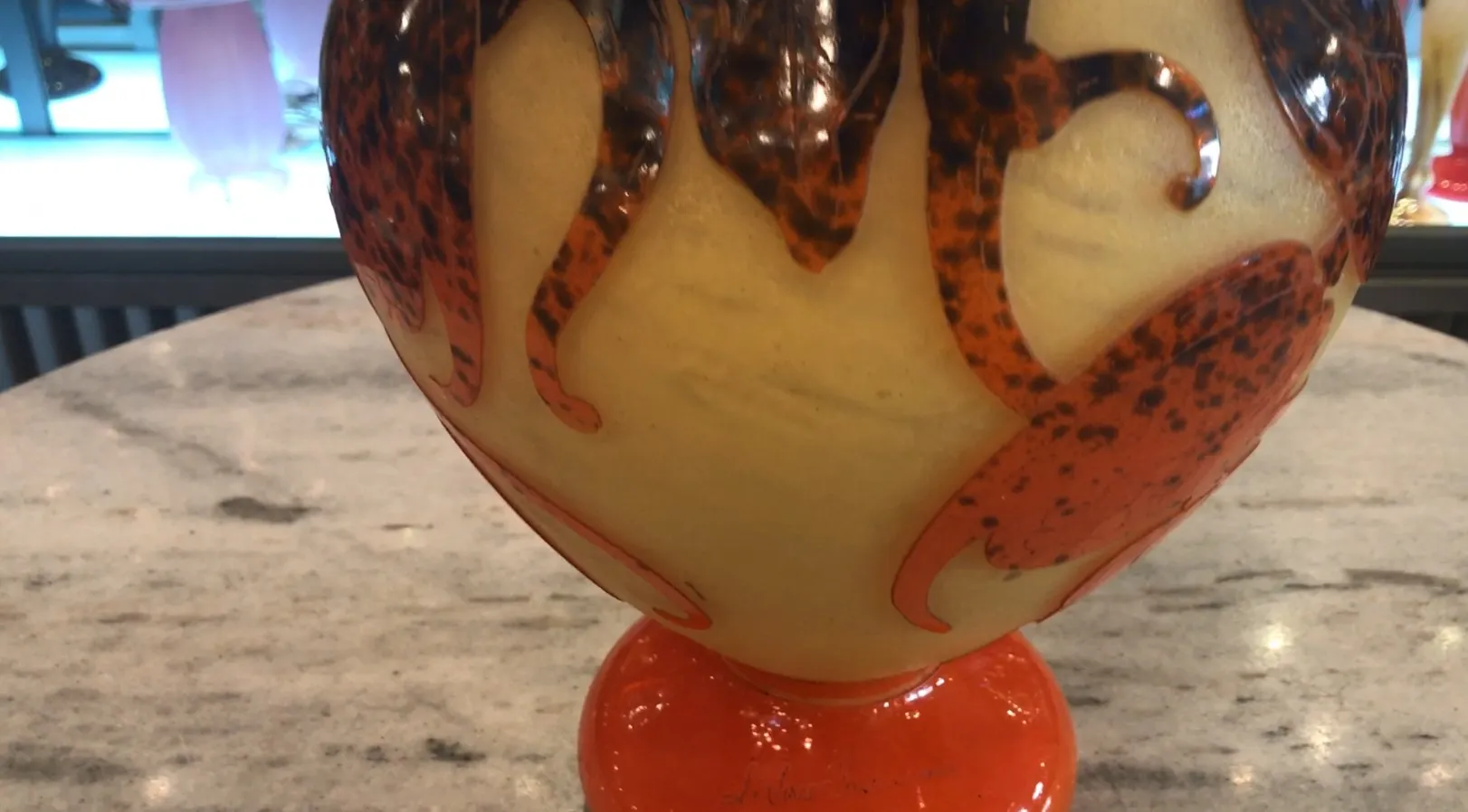 Verre ancien avec design distinctif et signature visible, coloré avec des détails artistiques