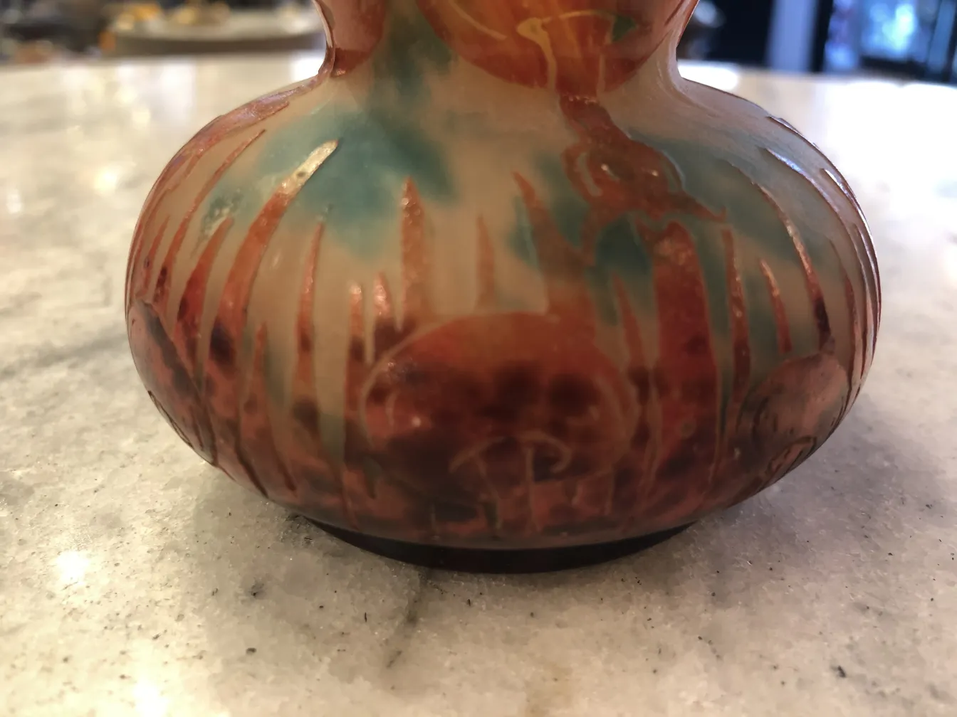 Vidrio antiguo firmado Le Verre en tonos cálidos en un entorno elegante.