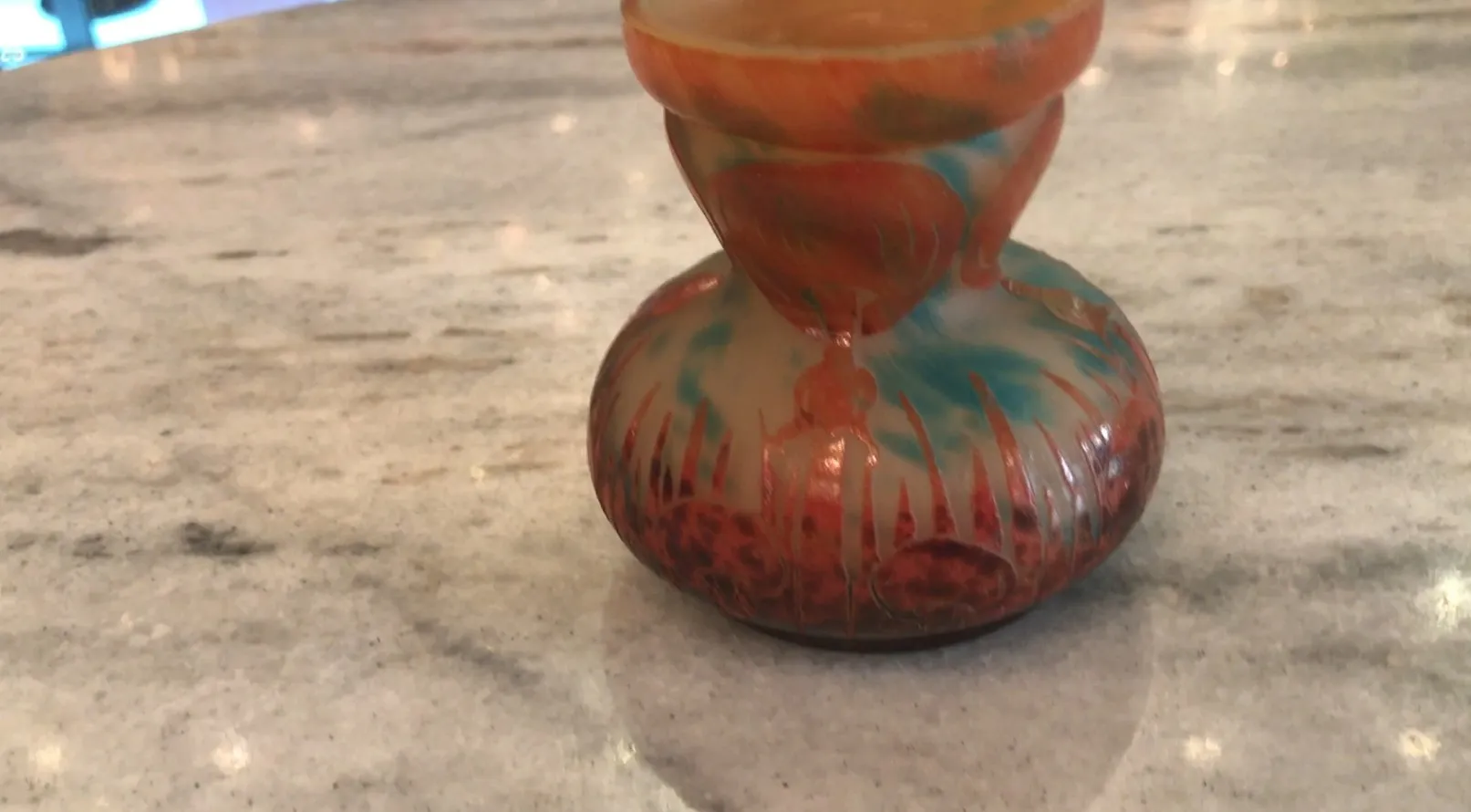 Antique signed glass with colorful design on a light background