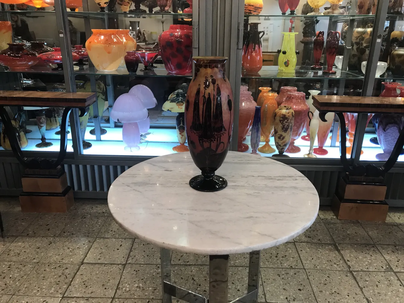 Подписанное стекло Le Verre на фоне декоративных предметов