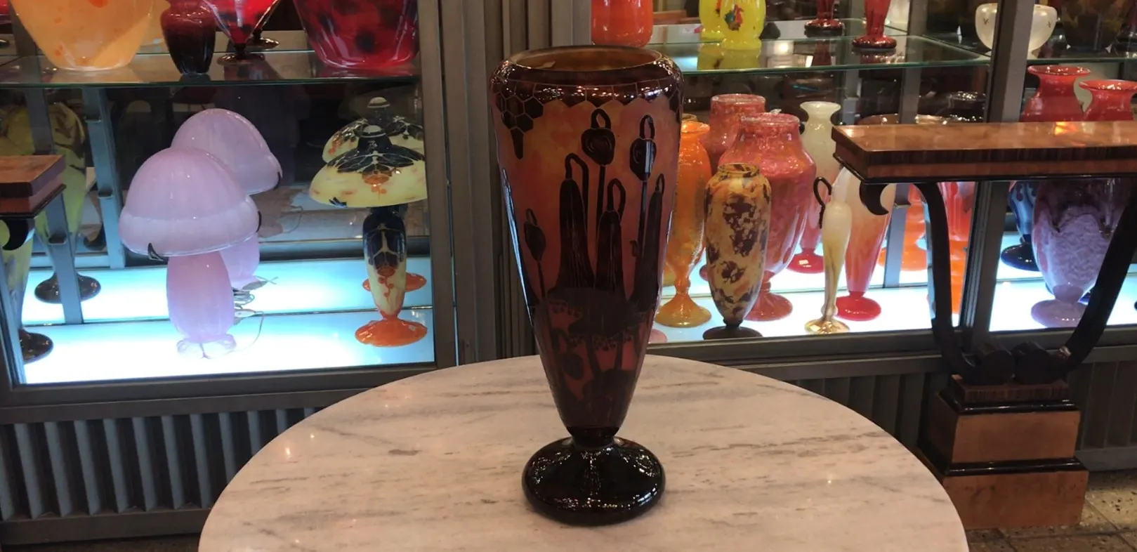 古いサイン入りグラス（Le Verre)（フランス）が色鮮やかな展示に囲まれています