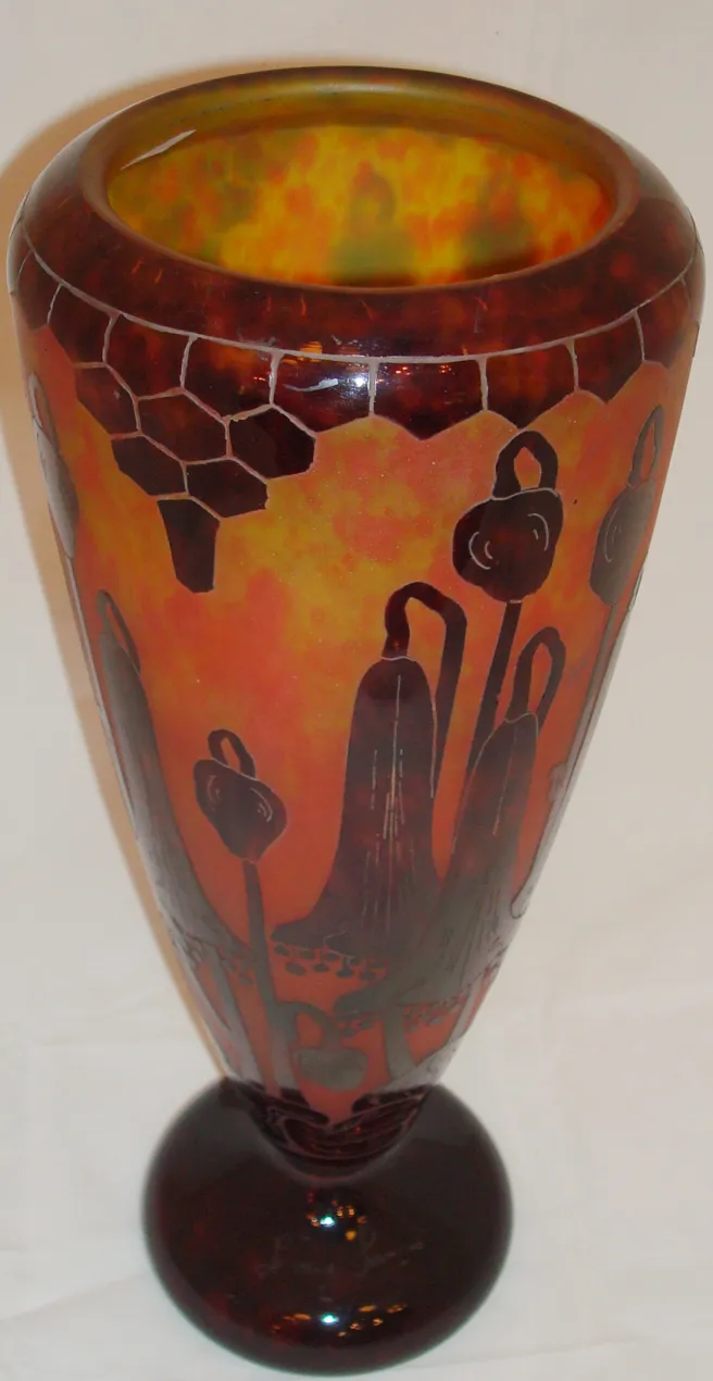 Vase gravé avec des motifs floraux sur fond orange.