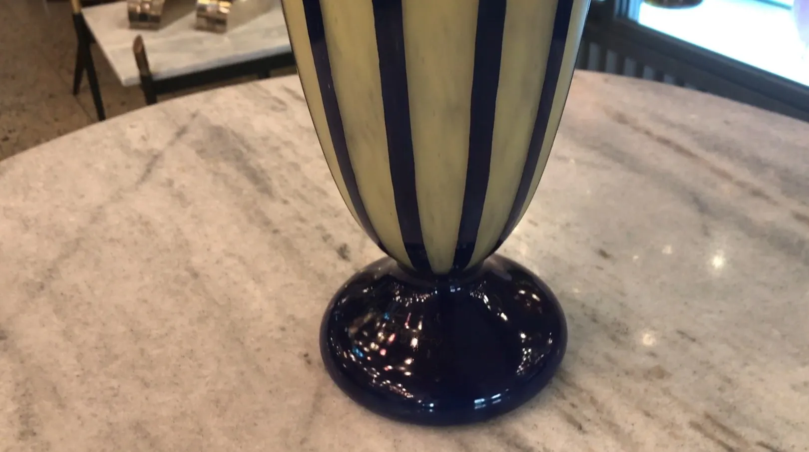 Verre signé Le Verre avec des rayures, base ronde dans un cadre élégant.