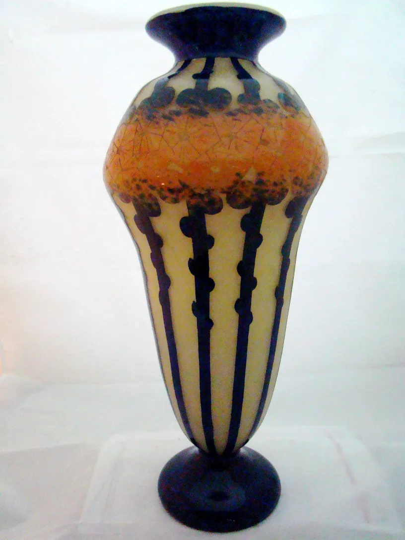 Jarrón antiguo decorado con motivo de líneas negras y tonos naranja.