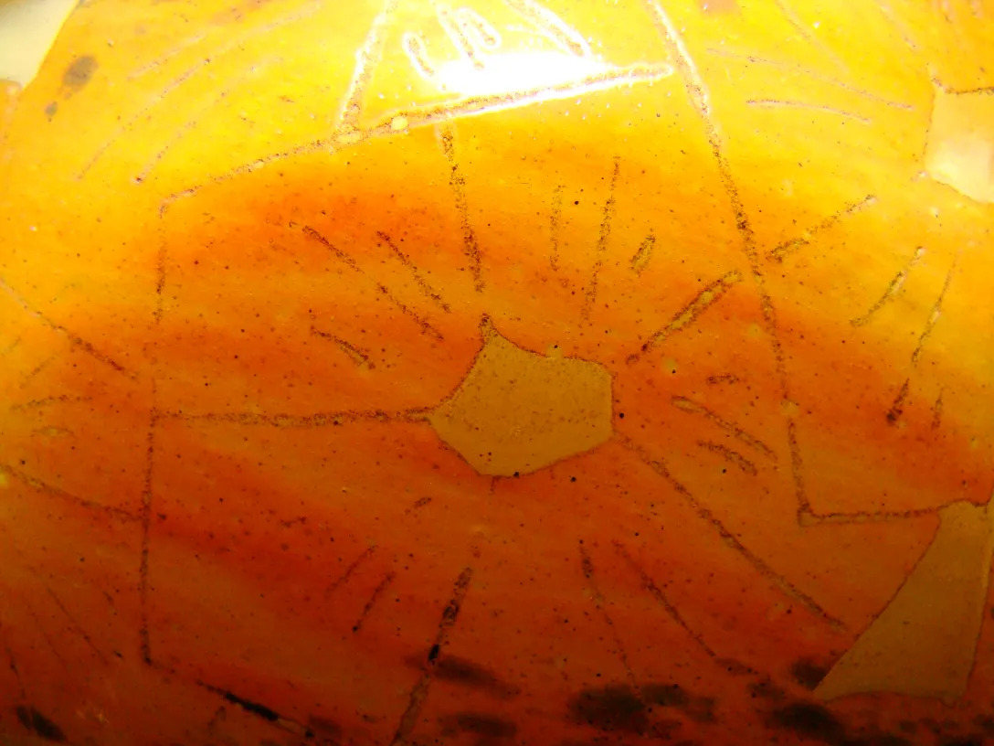 Vidrio antiguo con diseño amarillo y rayas, fondo claro.