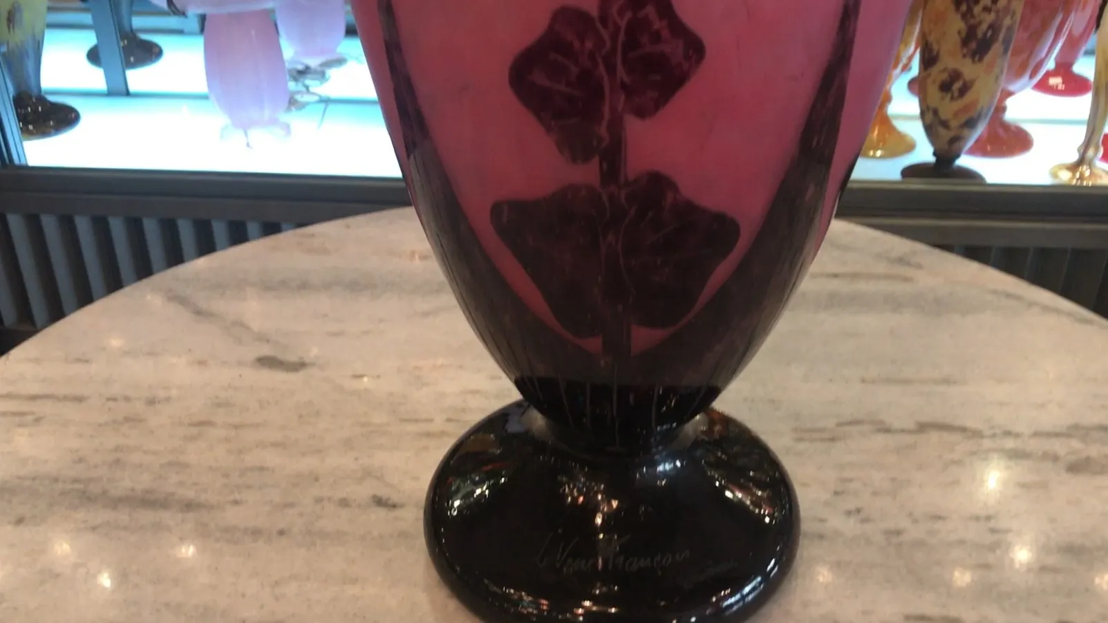 Vaso antigo com design floral em rosa profundo.