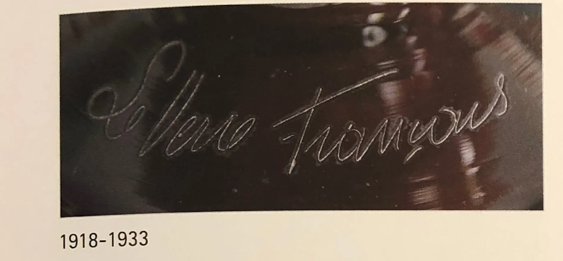 Detalles de una antigüedad con firma visible en vidrio; firma 'Le Verre'.