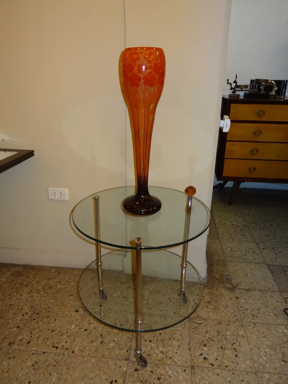 Vase orange avec motif floral, embellissant une table.