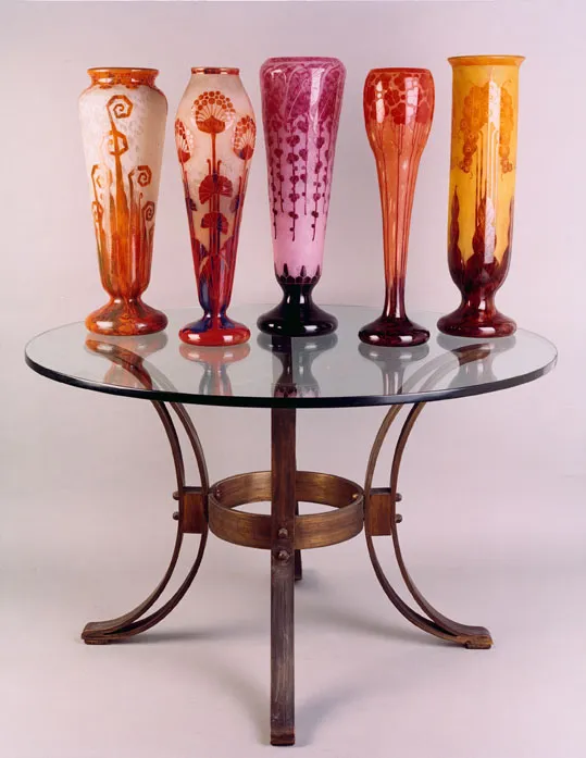 Ensemble de vases en verre anciens sur une table ronde.