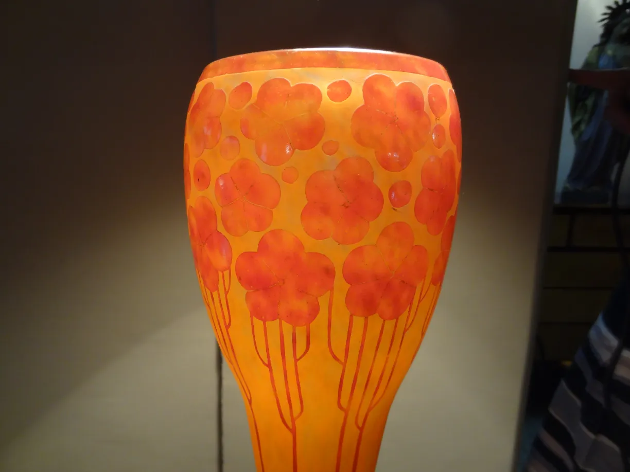 古いサイン入りグラス（Le Verre）明るい背景の上にオレンジ色の花柄。