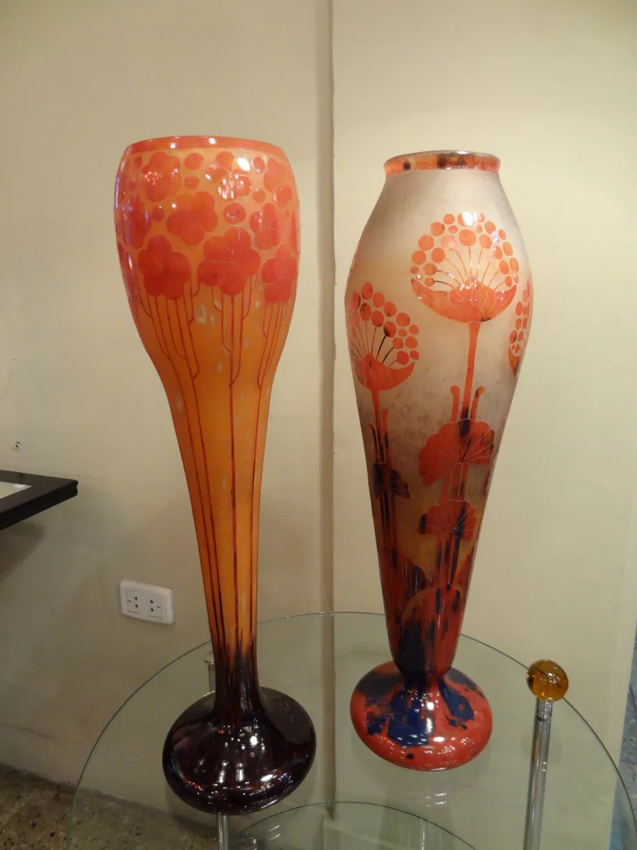 Dos jarrones antiguos de vidrio firmado Le Verre con diseño floral en colores naranja y rojo.