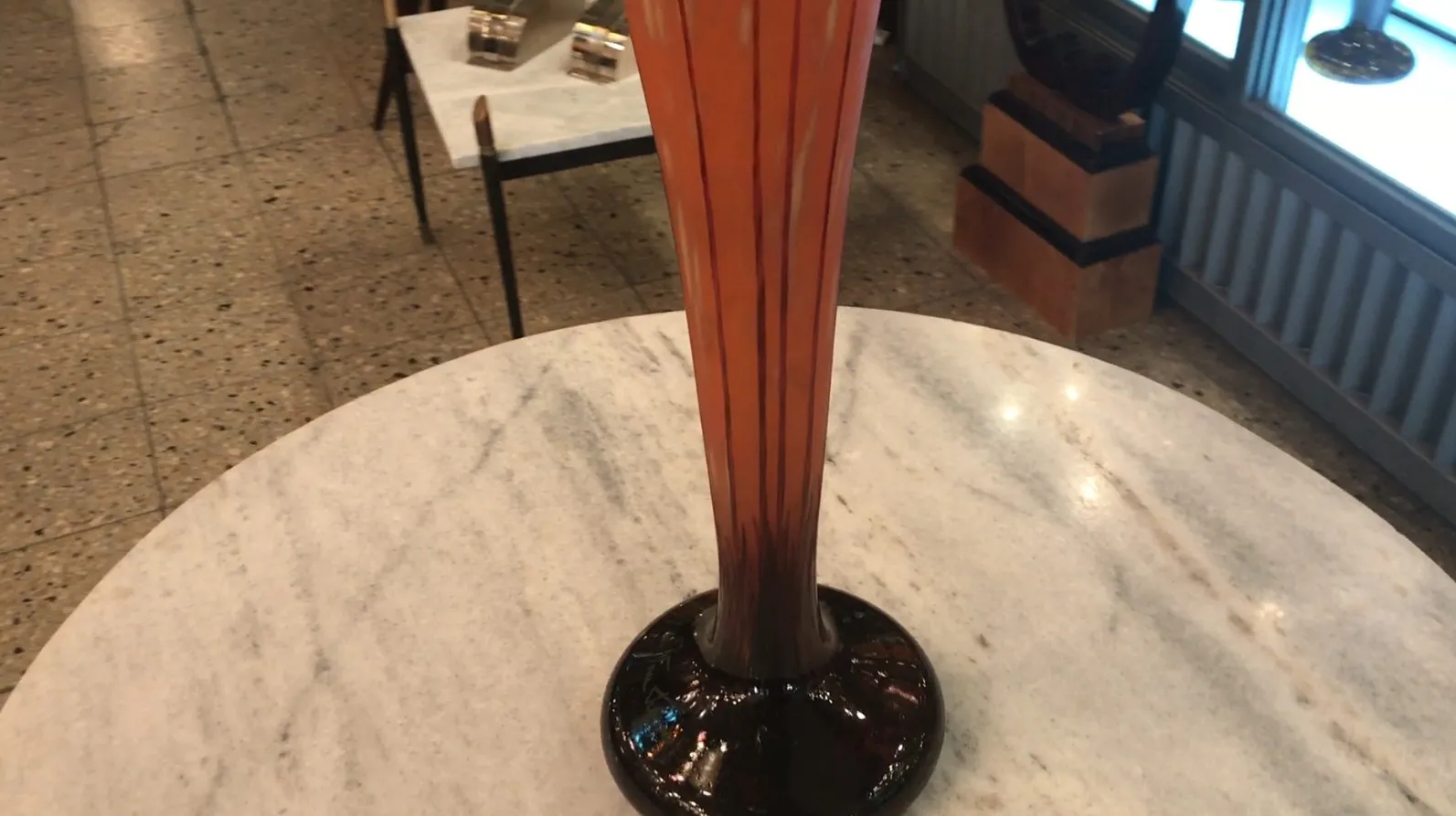 Vista de um vidro antigo assinado Le Verre em um ambiente elegante.