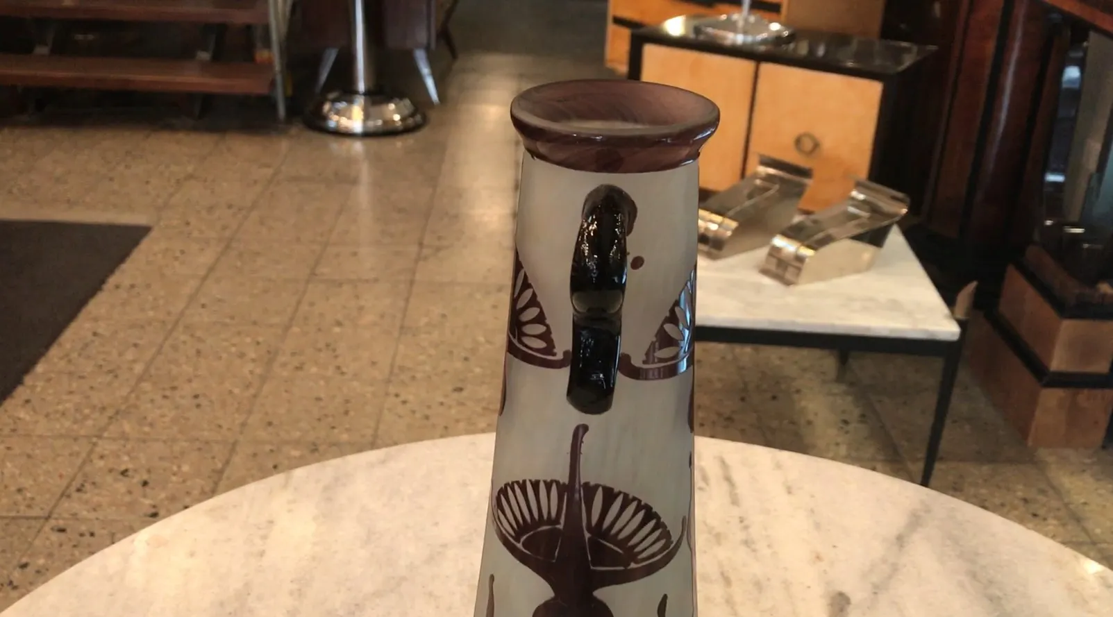 Antique glass with decorative details and table shadow.