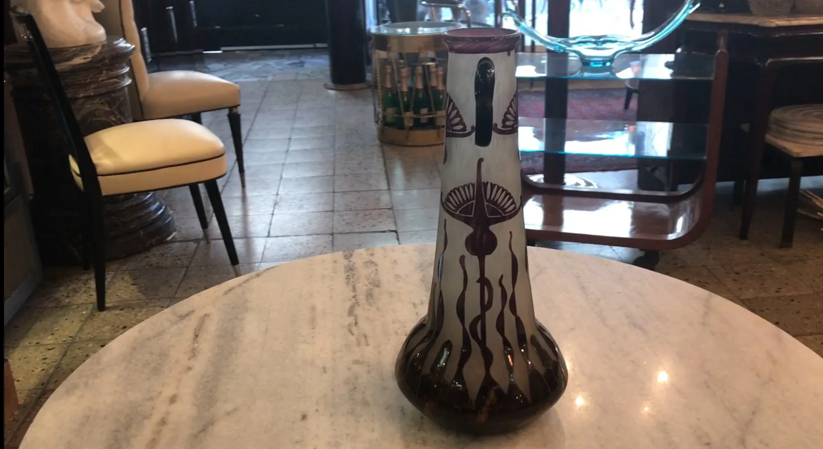 verre signé le verre avec décoration florale sombre sur une table en marbre